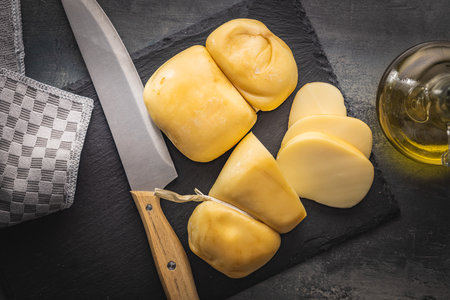 Smoked scamorza cheese on the cutting board. Top view.の写真素材