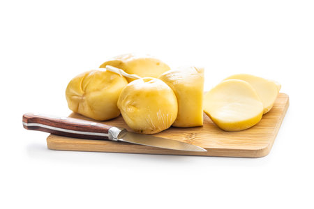 Smoked scamorza cheese on cutting board isolated on the white background.の写真素材