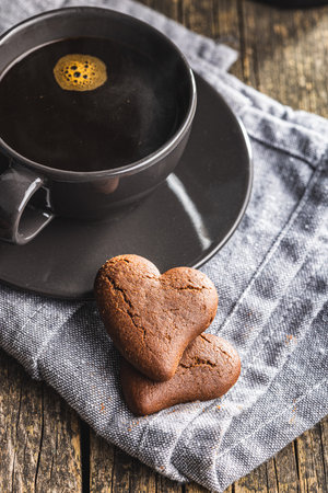 Heart shaped cookies and coffee cup on the wooden table.の写真素材