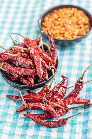 Red chili peppers in a bowl on the checkered tablecloth.の写真素材