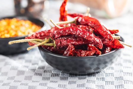Red chili peppers in a bowl on the checkered tablecloth.の写真素材