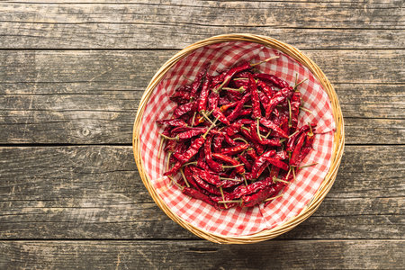 Red chili peppers in a bowl on the wooden table. Top view.の写真素材
