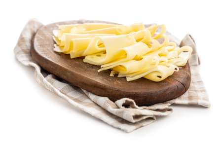 Slices of cheese on cutting board isolated on the white background.の写真素材