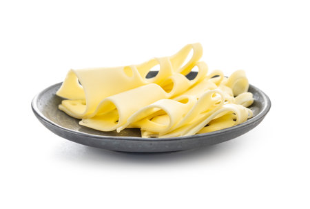 Slices of cheese on a plate isolated on the white background.の写真素材