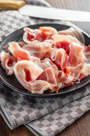 Italian Panchetta. Sliced smoked bacon on the plate.の写真素材