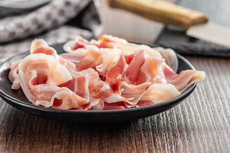Italian Panchetta. Sliced smoked bacon on the plate.の写真素材