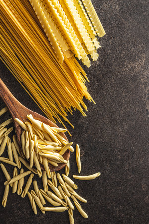 Fusilli Pugliese. Italian twisted pasta and spaghetti on the black table. Top view.の写真素材