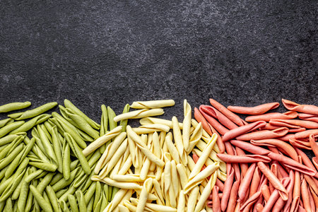 Fusilli Pugliese. Italian tricolor twisted pasta on the black table. Top view.の写真素材