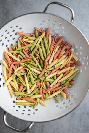 Fusilli Pugliese. Italian tricolor twisted pasta in the colander. Top view.の写真素材