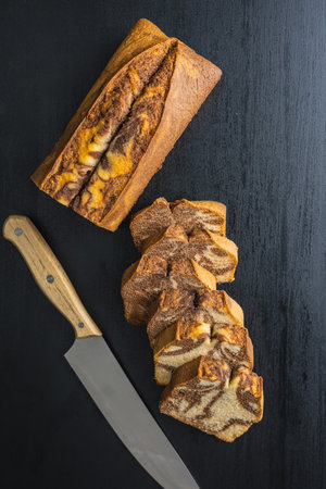 Marble sponge cake. Cake with cocoa and vanilla taste on the black table. Top view.の写真素材