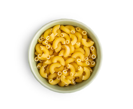 Raw macaroni pasta in a bowl. Uncooked rigatoni isolated on the white background.の写真素材