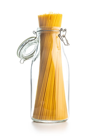 Spaghetti pasta in glass bottle. Uncooked italian pasta isolated on the white background.の写真素材