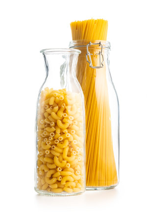 Raw macaroni pasta in glass bottle. Uncooked rigatoni isolated on the white background.の写真素材
