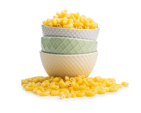 Raw macaroni pasta in a bowl. Uncooked rigatoni isolated on the white background.の写真素材