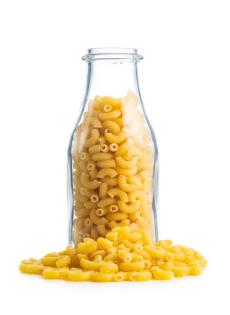 Raw macaroni pasta in glass bottle. Uncooked rigatoni isolated on the white background.の写真素材
