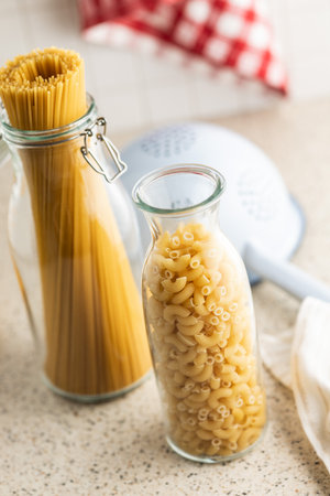 Raw macaroni pasta in glass bottle. Uncooked rigatoni in a glass bottle.の写真素材