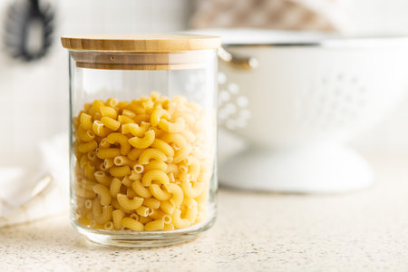 Raw macaroni pasta in glass bottle. Uncooked rigatoni in a glass jar.の写真素材