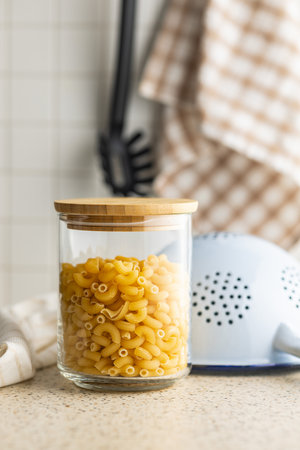 Raw macaroni pasta in glass bottle. Uncooked rigatoni in a glass jar.の写真素材