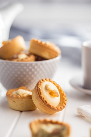 Sweet tartlets. Tasty mini tarts. Mini pie with cream on the kitchen table.の写真素材