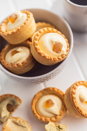 Sweet tartlets. Tasty mini tarts. Mini pie with cream in bowl on the kitchen table.の写真素材
