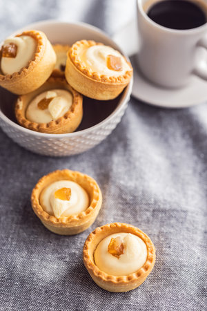 Sweet tartlets. Tasty mini tarts. Mini pie with cream on the kitchen table.の写真素材