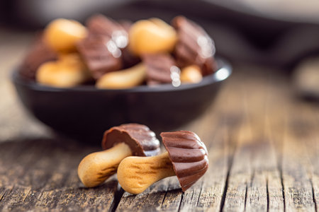 Candy in the shape of a mushroom. Chocolate mushrooms on the wooden table.の写真素材