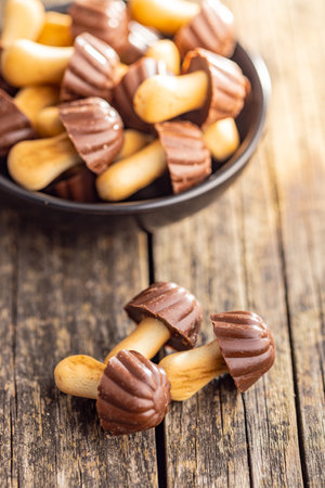 Candy in the shape of a mushroom. Chocolate mushrooms on the wooden table.の写真素材