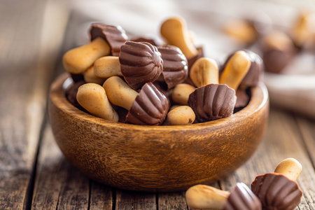 Candy in the shape of a mushroom. Chocolate mushrooms in a bowl on the wooden table.の写真素材