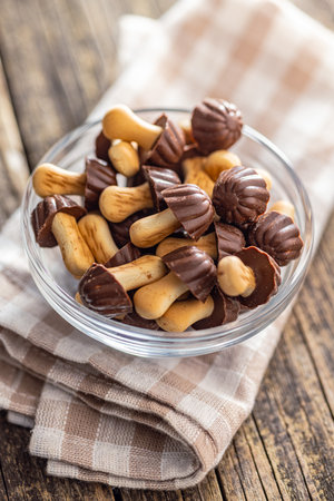 Candy in the shape of a mushroom. Chocolate mushrooms in a bowl on the wooden table.の写真素材