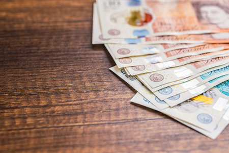 British pound sterling. Paper banknotes on the wooden table.