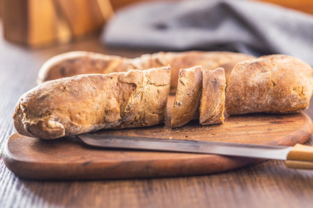 Wholegrain rustic baguette on the wooden table.の写真素材