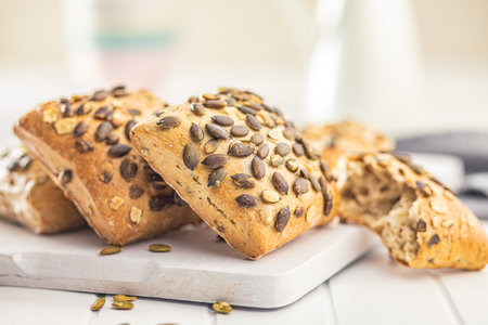 Whole grain bun with pumpkin seeds on the cutting board.の写真素材