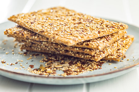 Knackebrot with sesame seeds. Wholegrain crispbread on plate on the kitchen table.の写真素材