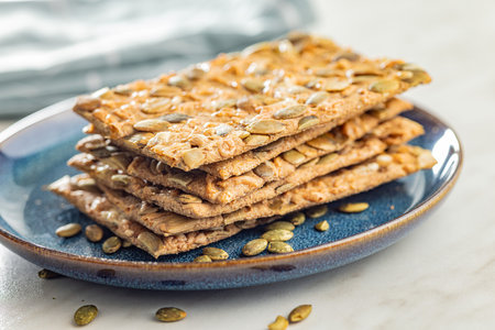Knackebrot with sesame seeds. Wholegrain crispbread on plate on the kitchen table.の写真素材