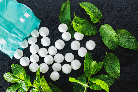 Mint candies. Menthol candies and mint leaves on the black table. Top view.の写真素材