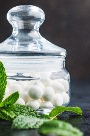 Mint candies in jar. Menthol candies and mint leaves on the black table.の写真素材