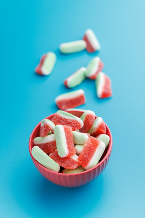 Watermelon jelly candies in bowl on the blue table.の写真素材