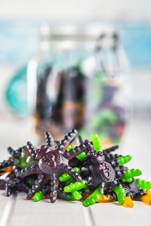 Scary sweet jelly spiders. Halloween candies on the white table.の写真素材