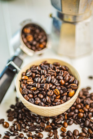 Roasted coffee beans in a bowl on the white kitchen table.の写真素材