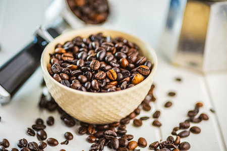 Roasted coffee beans in a bowl on the white kitchen table.の写真素材