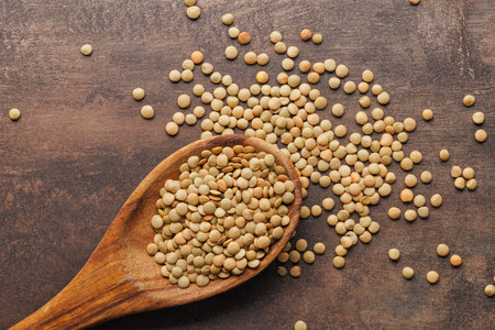 Uncooked lentil legumes in the wooden spoon. Top view.の写真素材