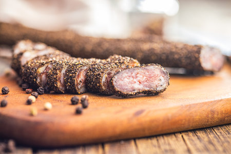 Smoked dried sausage. Sliced sausage on the cutting board.の写真素材