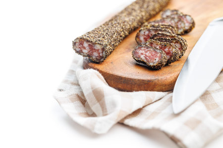 Smoked dried sausage. Sliced sausage on cutting board isolated on the white background.の写真素材