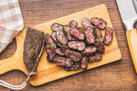 Smoked dried sausage. Sliced sausage on the cutting board. Top view.の写真素材