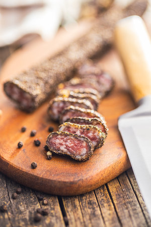 Smoked dried sausage. Sliced sausage on the cutting board.の写真素材