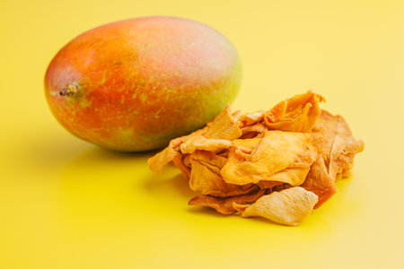 Dried mango fruit on the yellow background.の写真素材