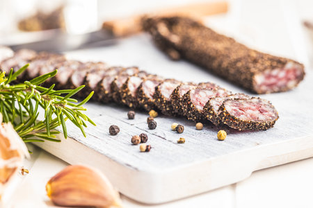 Smoked dried sausage. Sliced sausage on the cutting board.の写真素材