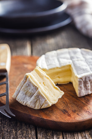 Brie type cheese with white mold. French camembert cheese on the cutting board.の写真素材