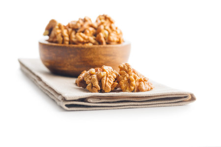 Peeled dried walnut kernels on a napkin isolated on the white background.の写真素材