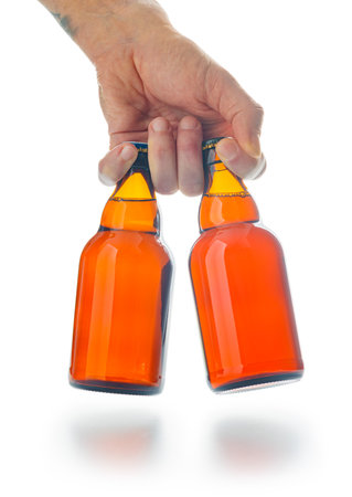 Bottles of beer in hand isolated on the white background.の写真素材